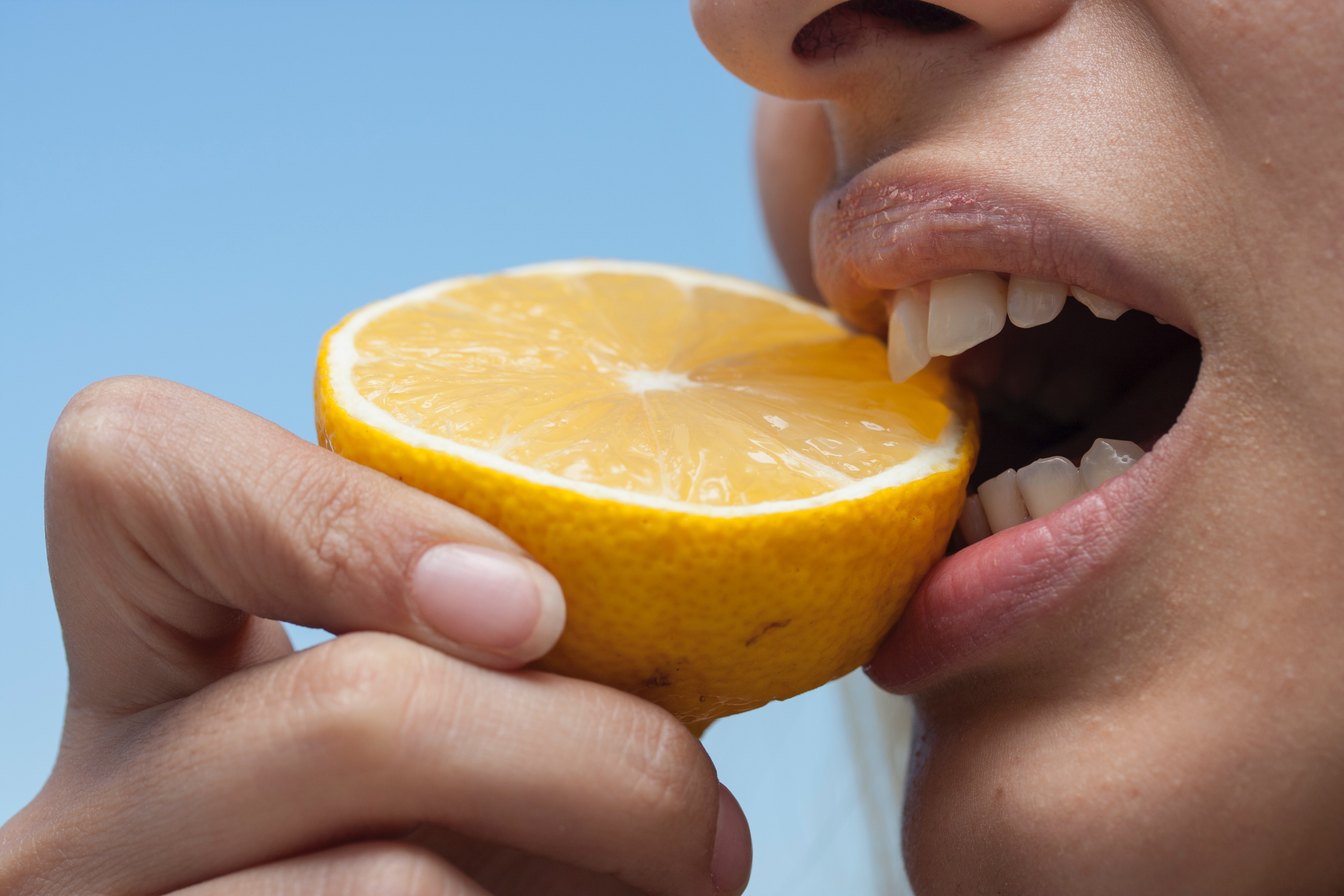 Person Biting Lemon With Sensitive Teeth