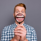 A Man With A Magnifying Glass Showing His Teeth