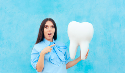 Funny Woman Holding Oversized Tooth In Dentist Concept Image