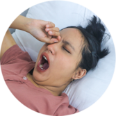 A Sleepy Woman Yawing On The Bed